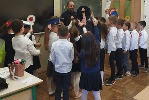 umundurowany policjant otoczony dziećmi