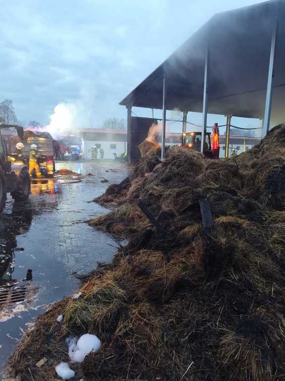 słoma i siano obok służby ratunkowe wokół nich dym