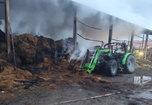 spalony budynek gospodarczy obok nadpalony traktor