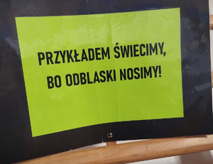 żółta kartka  z napisem promującym noszenie odblasków