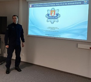 umundurowany policjant przed ekranem z prezentacją