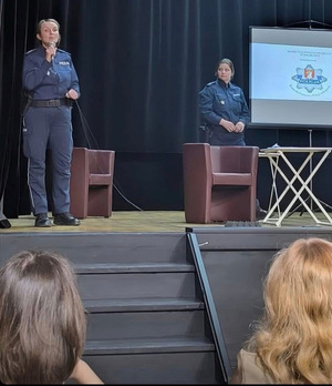 dwie umundurowane policjantki na scenie przed nimi widownia