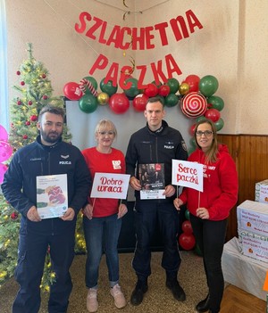 umundurowani policjanci i dwie wolontariuszki z tyłu napis Szlachetna Paczka