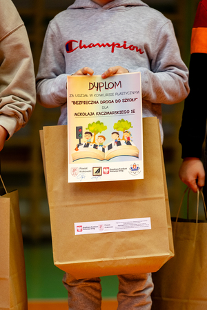 chłopiec trzymający w rękach dyplom