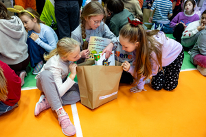 trzy dziewczynki na podłodze oglądają nagrody