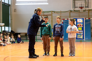 umundurowana policjantka przed nią stoi trójka dzieci