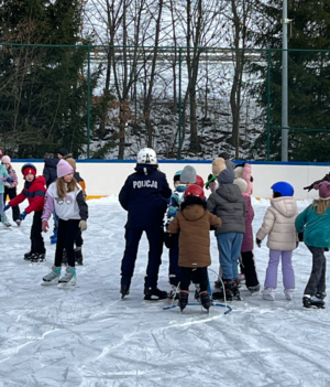 policjantka z dziećmi na płycie lodowiska
