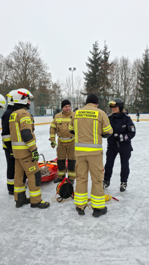 policjantka i strażacy na lodowisku