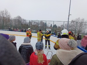 strażacy i uczniowie podczas zajęć na
