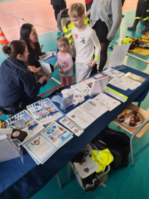 policjantka wręcza dzieciom ulotki