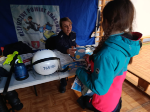 policjantka wręcza dziewczynce ulotkę