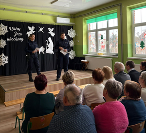 policjantki w mundurach przed nimi siedzą seniorzy