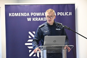 policjant w mudnurze przemawia do mikrofonu