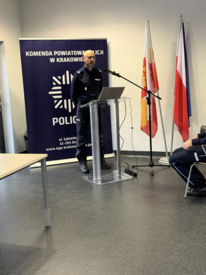 policjant w mundurze stojący za mównicą2