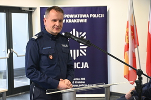 policjant w mudnrze stoi za mównicą