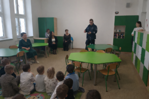 policjant w mundurze przed nim dzieci oraz inni uczestnicy