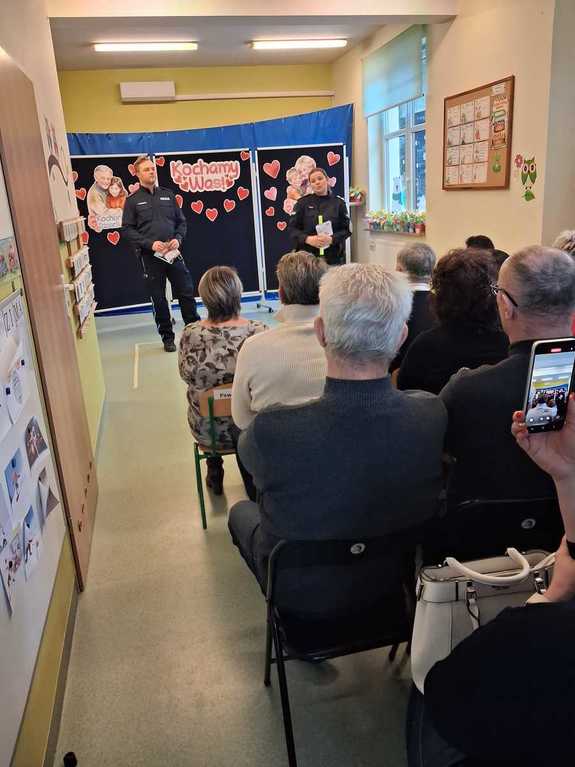 umundurowani policjanci przed nim seniorzy