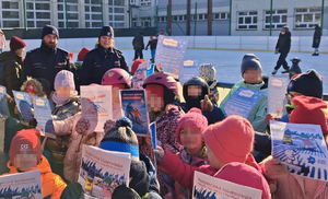 dzieci przy lodowisku obok policjanci z mundurach