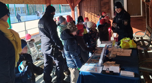 umundurowani policjanci z dziećmi przy lodowisku