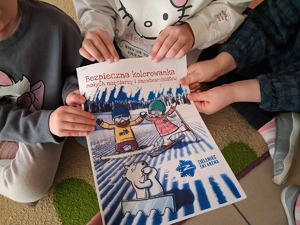 ulotka bezpieczne ferie w dłoniach dzieci