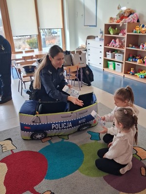 umundurowana policjantka w zabawkowym radiowozie