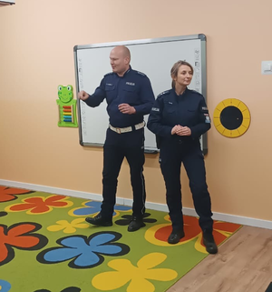 policjantka i policjant w mudurach w sali przedszkolnej