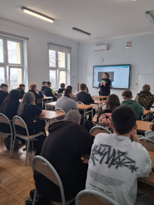 policjantka w mundurze podczas prelekcji w klasie przed nią siedzą uczniowie