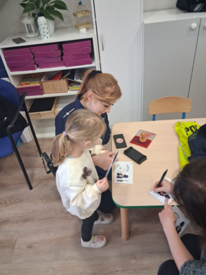 policjantka odbija odciski paluszków dziewczynce