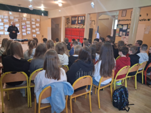 policjanci przed nimi siedzą uczniowie