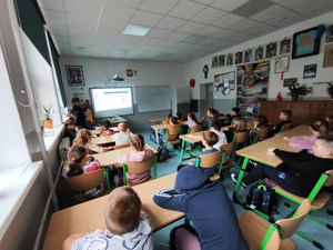 policjantka w mundurze w sali lekcyjnej przed nią siedzą dzieci w ławkach