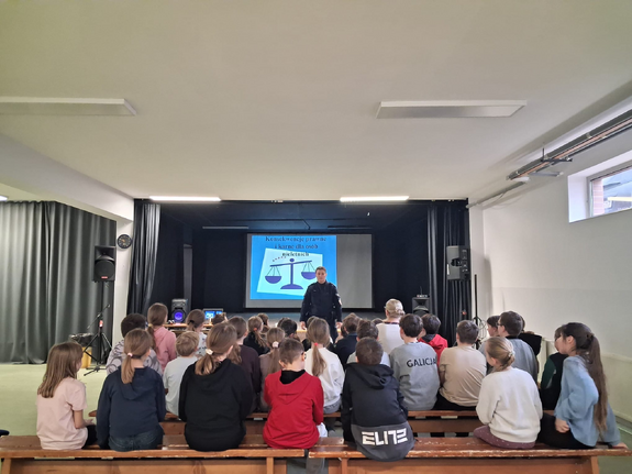 policjantka na sali przed nią siedzą uczniowie