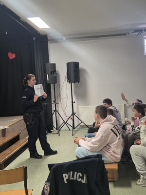 policjantka w mundurze podczas wykładu przed nią siedzą uczniowie