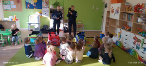 policjantki w mundurach przed nimi siedzą przedszkolaki w sali