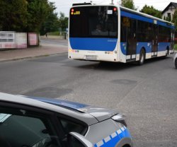 odjeżdżający autokar i stojący na poboczu radiowóz