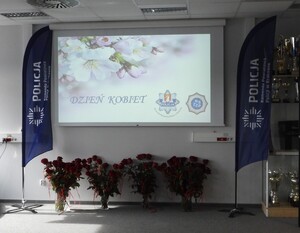 wyświetlony na rzutniku napis dzień kobiet na podłodze w wazonach stoją róże