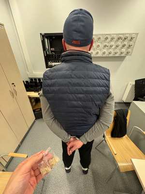 mężczyzna stojący tyłem ręce skute kajdankami