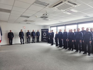 policjanci w mundurach na sali podczas uroczystej zbiórki