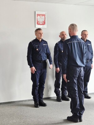 policjant odbiera rozkaz personalny z rąk komendanta