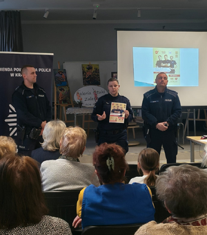 policjanci w mundurach przed nimi siedzą uczestnicy spotkania