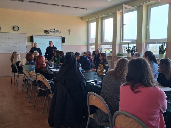 policjanci podczas spotkania w sali przed nimi siedzą uczestnicy