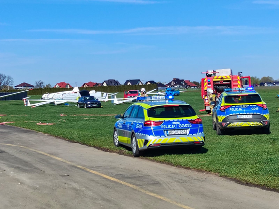 oznakowane radiowozy i wóz strażacki na płycie lotniska