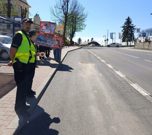 policjanci w mundurach stoją przy drodze