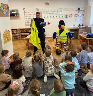 policjantka pokazuje dzieciom wyposażenie  i umundurowanie policjantów