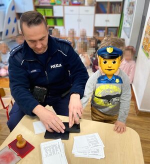 policjant odbija odciski paluszków dziecka