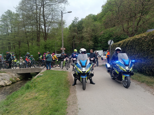 policjanci na policyjnych motorach za nimi uczestnicy rajdu na rowerach