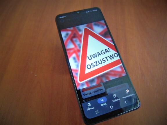 Telefon komórkowy z ostrzeżeniem Uwaga Oszustwo