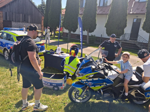 policyjny motor na którym siedzi dziecko obok stoi policjant