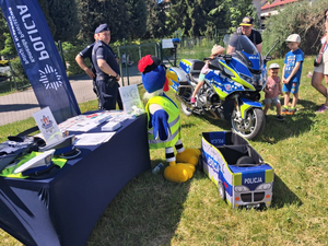 policyjne stoisko i motor a przy nim osoby oglądające