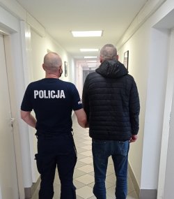 policjant z zatrzymanym, stojący tyłem