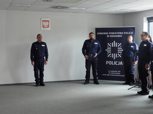 policjanci w mundurach w sali podczas uroczystej zbiórki